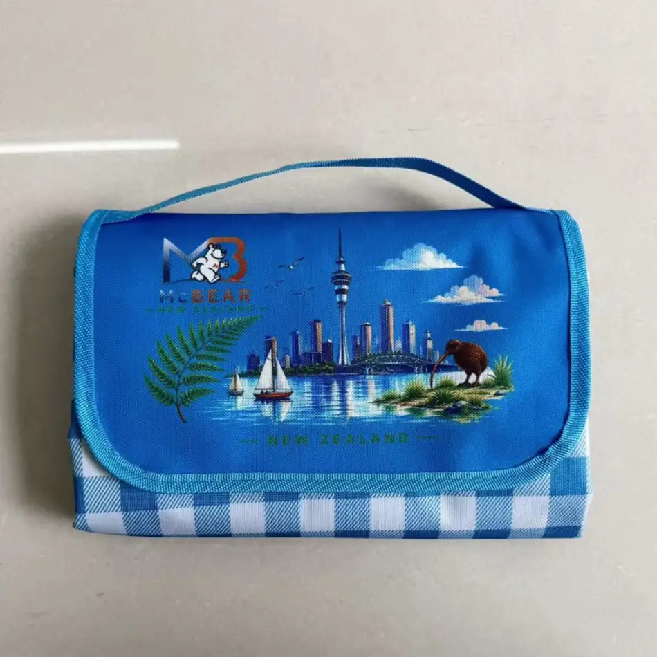 MC Bear NZ Picnic Mat folded into its blue carry bag with the New Zealand print